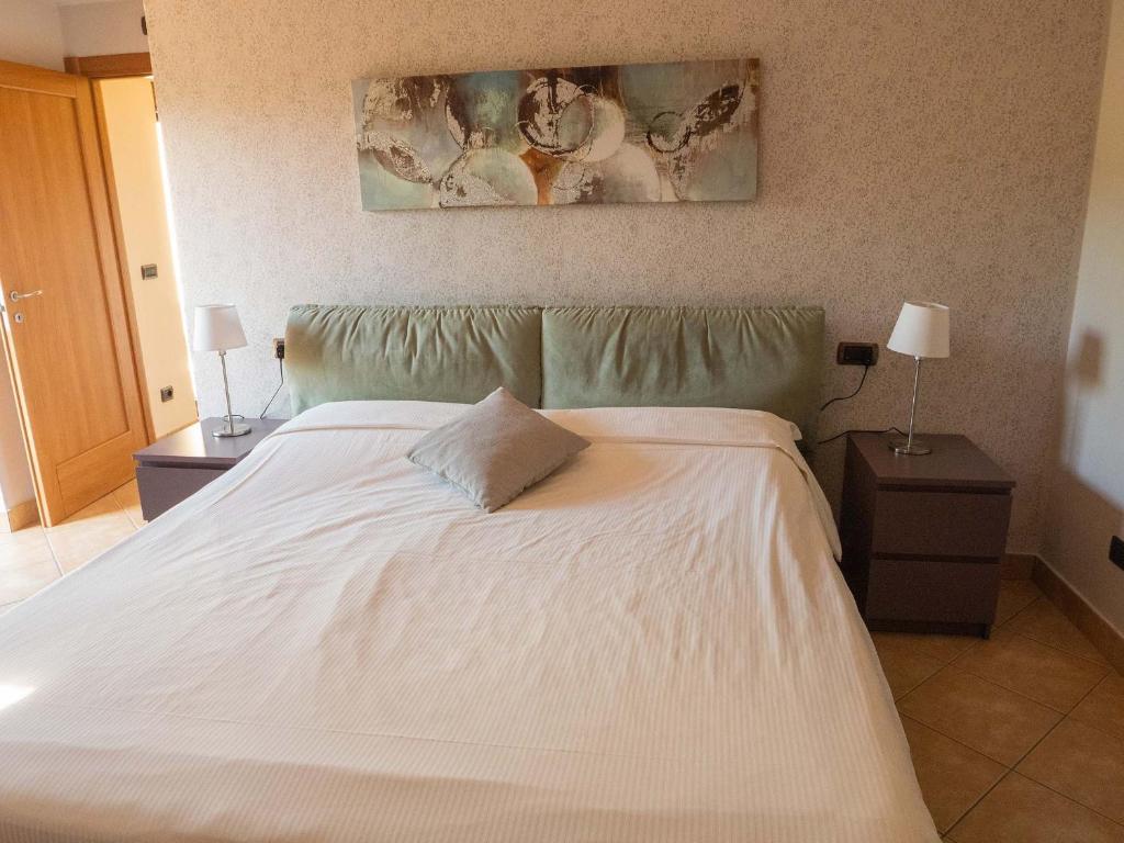 białe łóżko z poduszką na górze w obiekcie Villa Olivee w mieście Bellagio