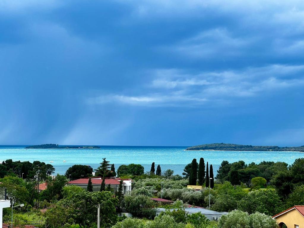 vistas al océano y a una ciudad con árboles en Fažana INN, en Fažana