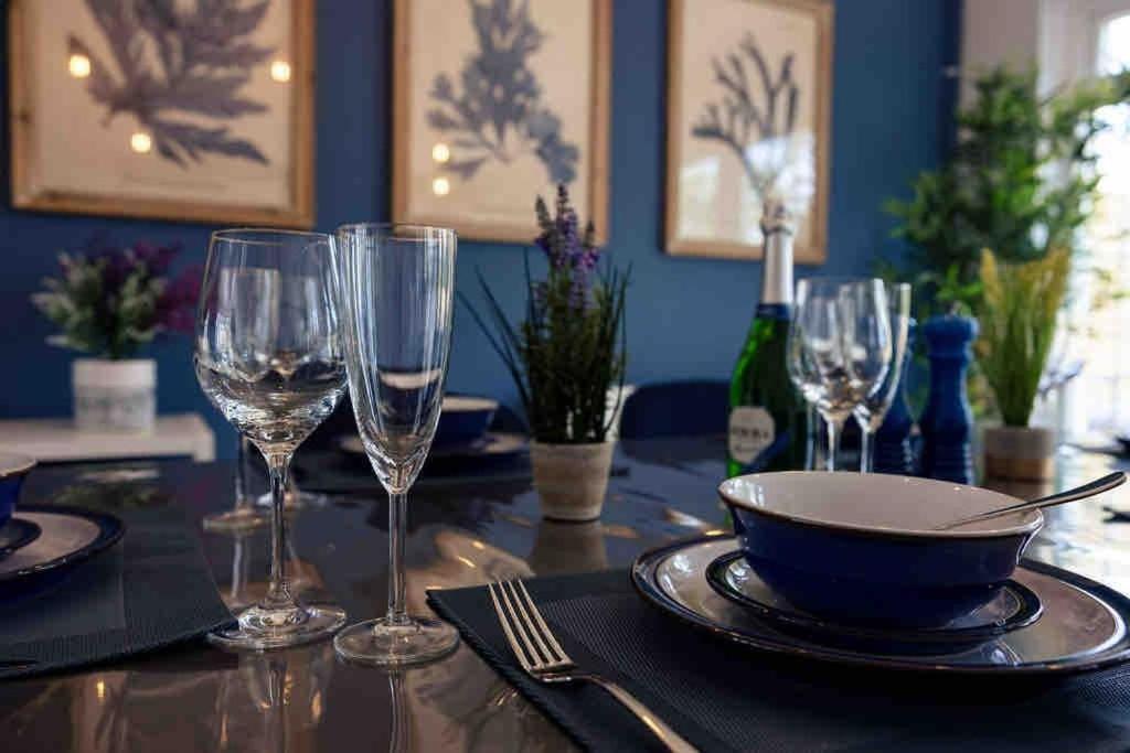 a table with wine glasses and a bowl on it at Braunton Beach Boutique in Wrafton