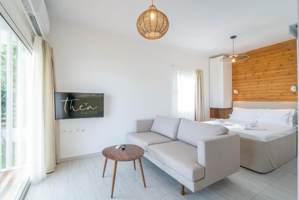 a living room with a couch and a bed at Thea Eco Suites in Nea Kalikratia