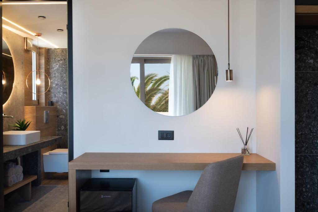 a mirror hangs above a desk in a room at Prasonisi Light House Boutique Hotel in Prasonisi