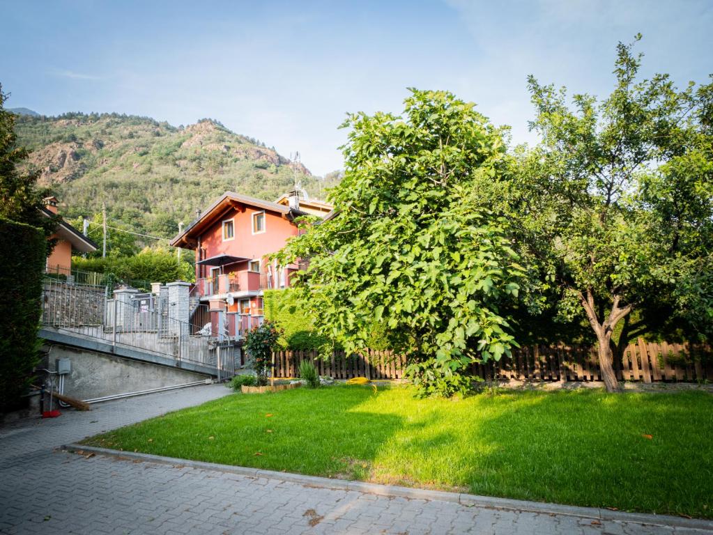 un árbol en un patio con una casa en Casa Celesta, en Aosta