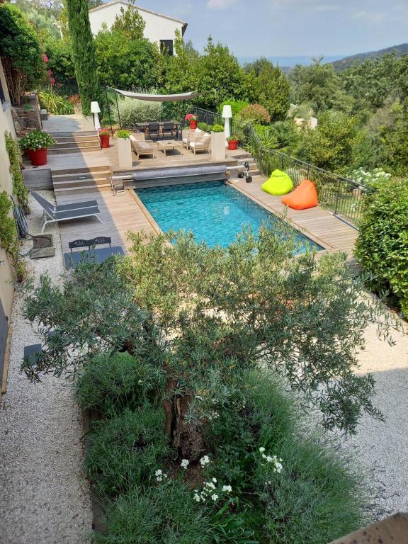 um quintal com uma piscina e uma casa em Rez de Jardin d'une Bastide VILLA LA GARDI avec Piscine privée em La Garde-Freinet
