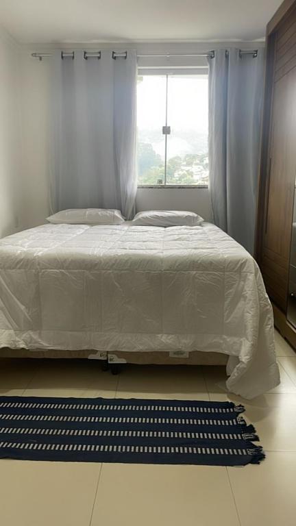 ein Schlafzimmer mit einem weißen Bett und einem Fenster in der Unterkunft Santa Teresa dos Colibris in São Roque