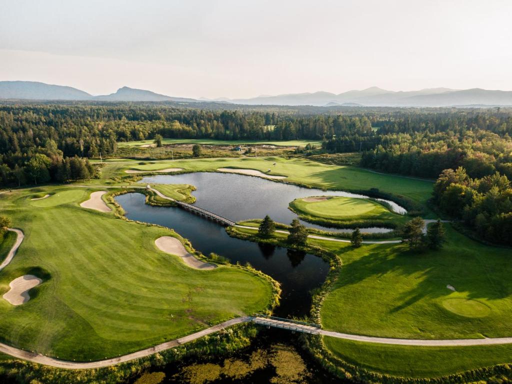 an aerial view of a golf course with a lake at Destination Owl's Head - Mtn Haus in Mansonville