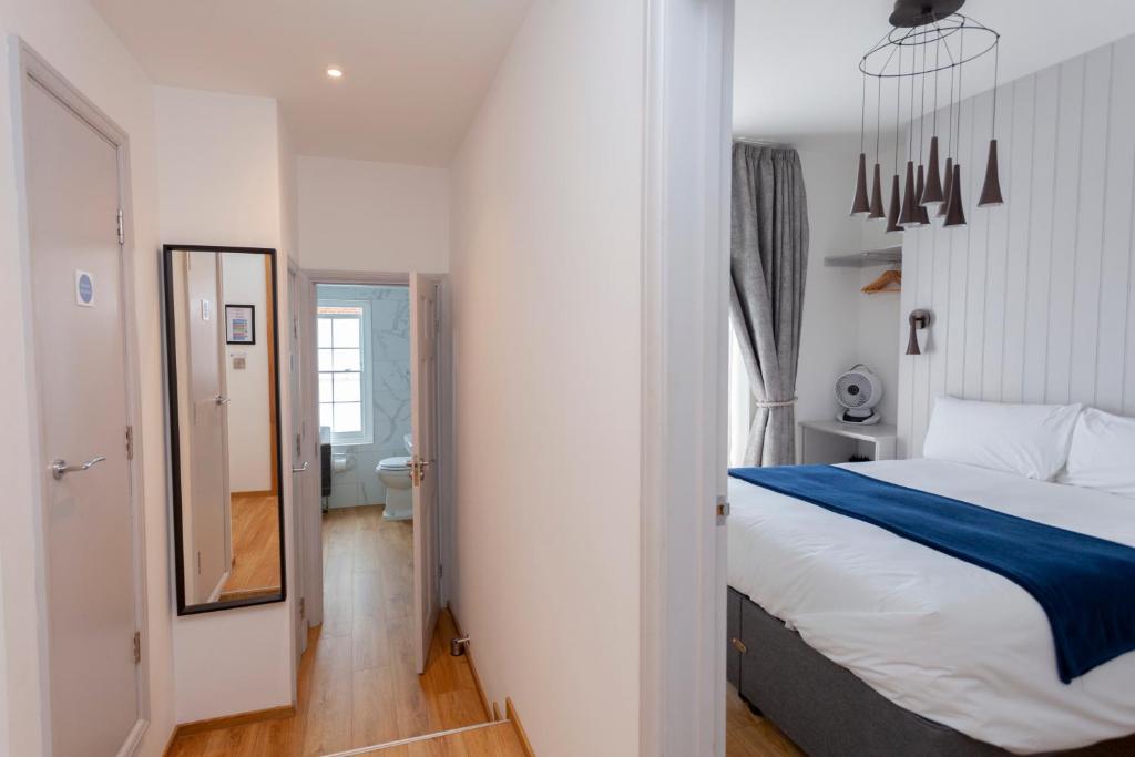 a bedroom with a large bed and a bathroom at Apartment 4 at Number 8 in City centre with kitchenette in Kent