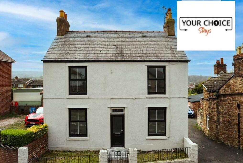 Una casa blanca con un cartel que dice que lo sientes en Lovely detached Cottage, Flint en Flint