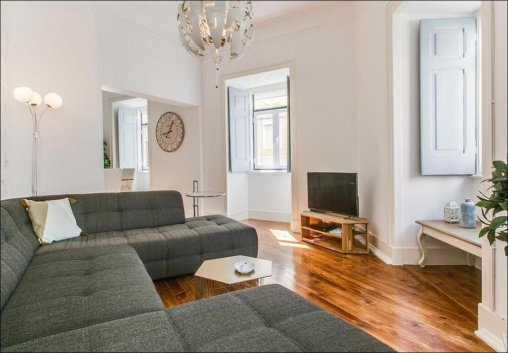 uma sala de estar com um sofá e uma televisão em Zaire Retreat Apartment em Lisboa
