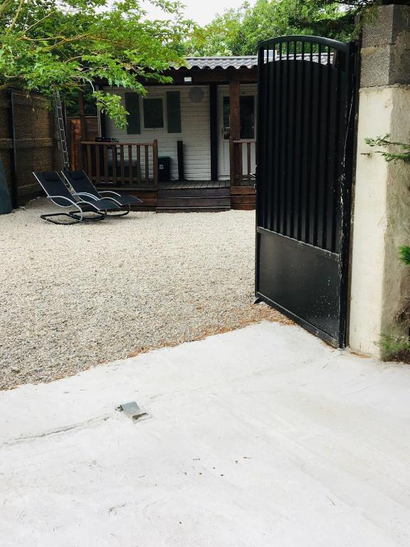 deux chaises devant une maison avec un portail dans l'établissement Mobil-home sur terrain privé, à Sérignan