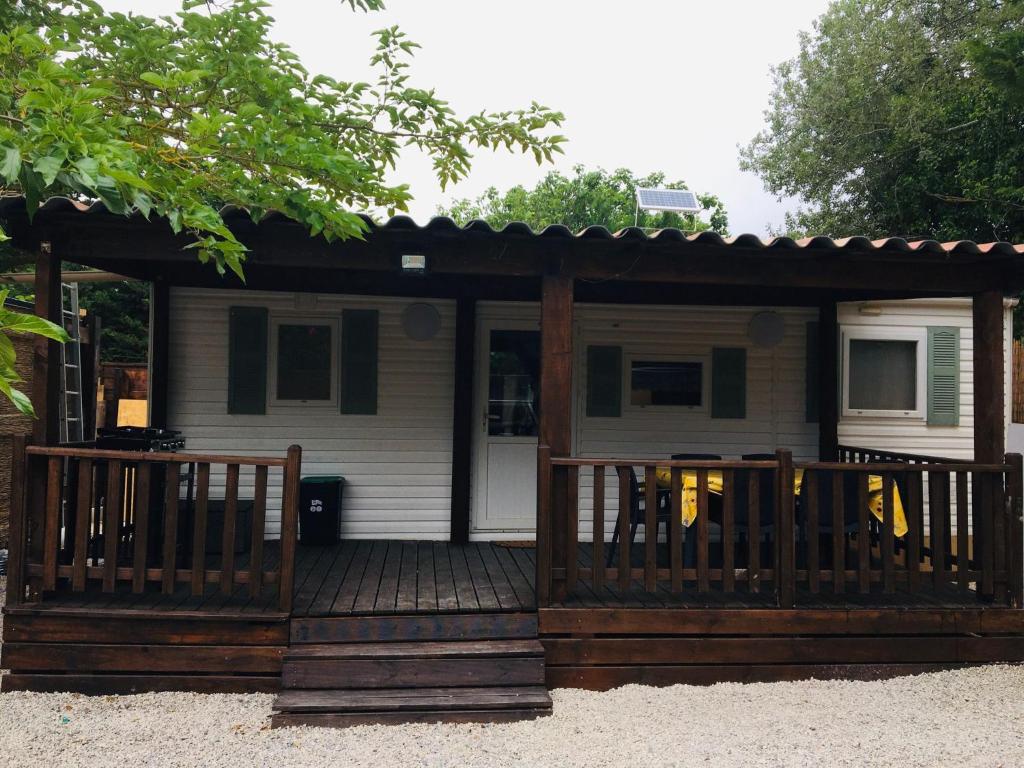 a screened in porch with a wooden deck at Mobil-home sur terrain privé in Sérignan