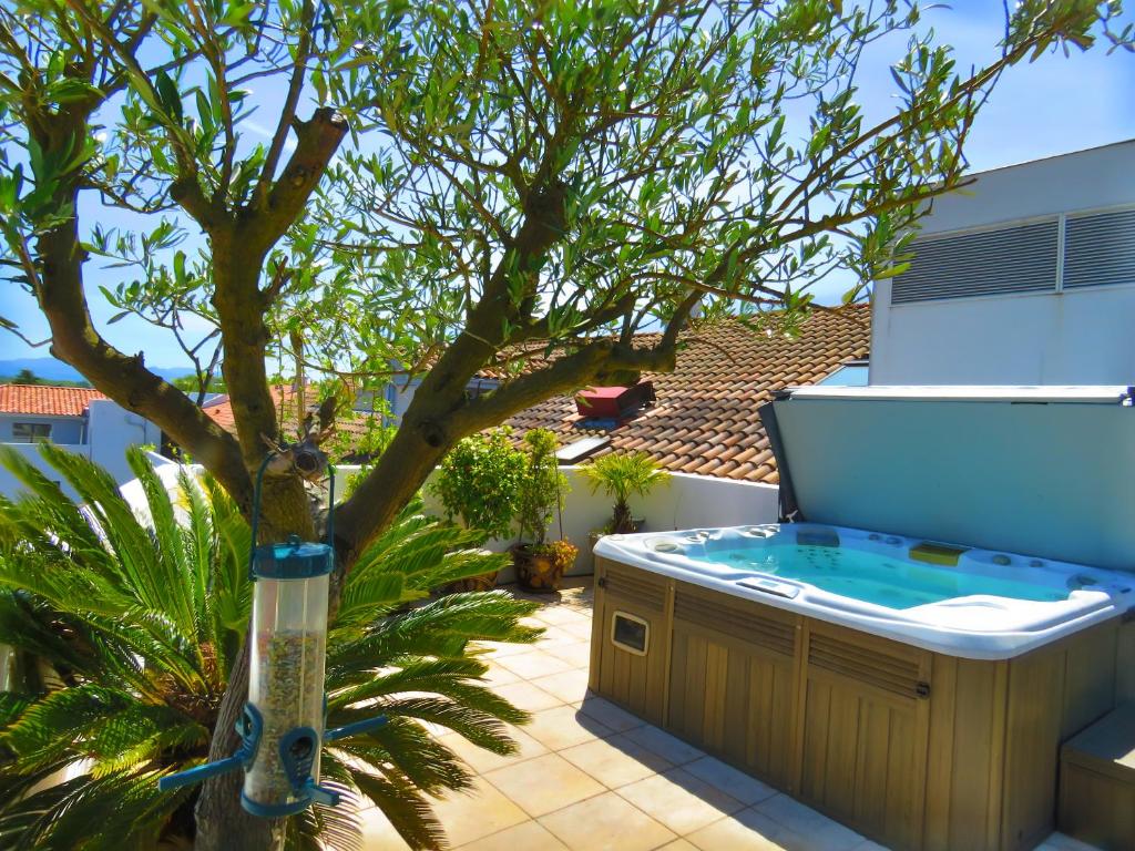 a hot tub sitting next to a tree in a yard at L&#39;OASIS - Loft standing - Terrasse Rooftop - Jacuzzi Spa - Parking in Bayonne