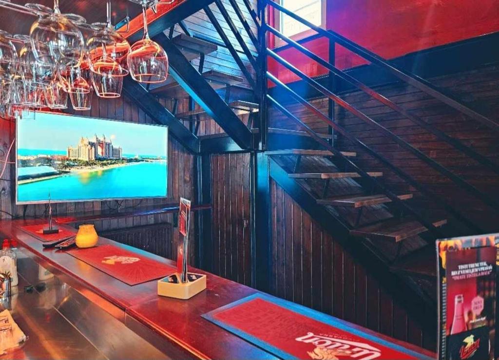 Hostel Bermuda في ليسْتْسي: بار مع طاولة وتلفزيون على الحائط