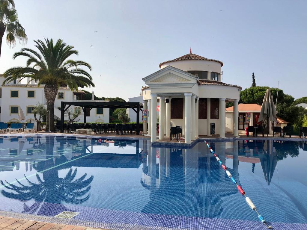 una piscina frente a un edificio con una casa en The Old Village Studio Vilamoura, en Vilamoura