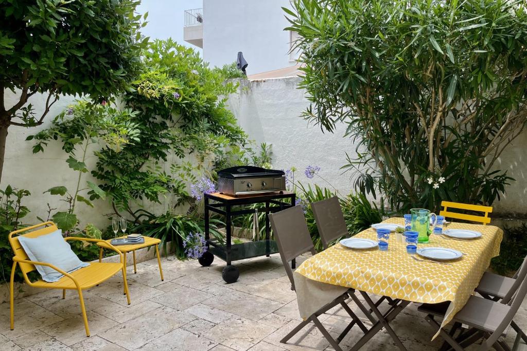 un patio avec une table, des chaises et un barbecue dans l'établissement Havre de paix à 200m de la mer, à Les Sables-dʼOlonne