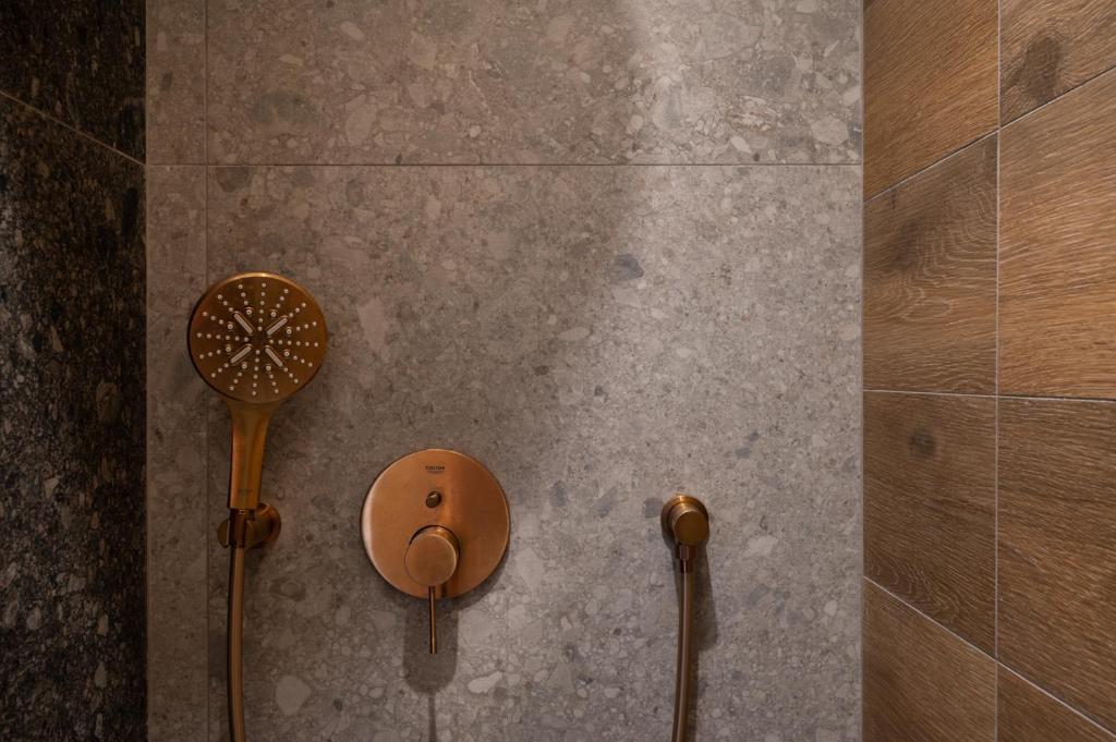 a shower with two shower heads on a tiled wall at Prasonisi Light House Boutique Hotel in Prasonisi