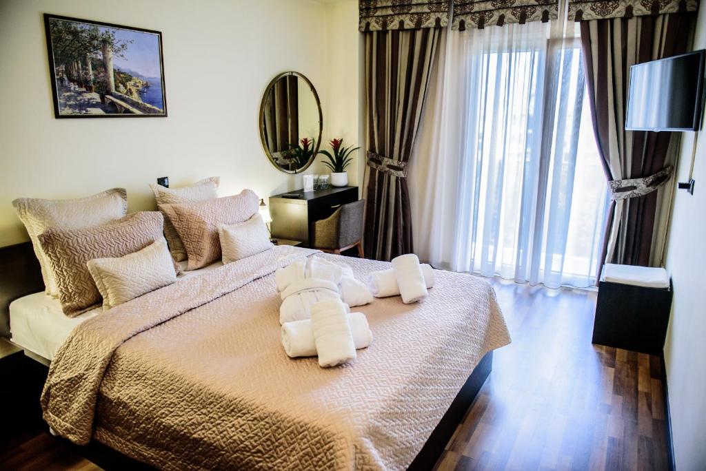 1 dormitorio con 1 cama con toallas en Hotel Padelidaki en Tríkala