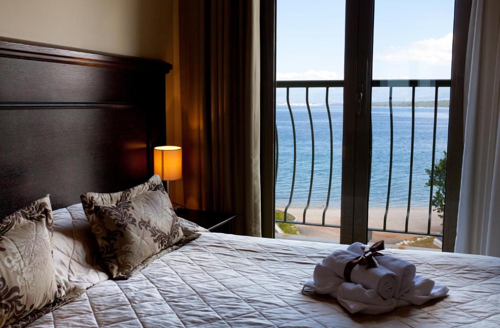 a bedroom with a bed with a view of the ocean at Blue Waves Resort in Malinska