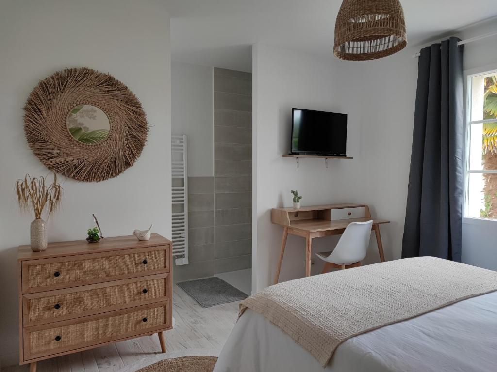 una camera da letto con un letto, un comò e uno specchio di La Parenthèse Cormillonne a Corme-Écluse