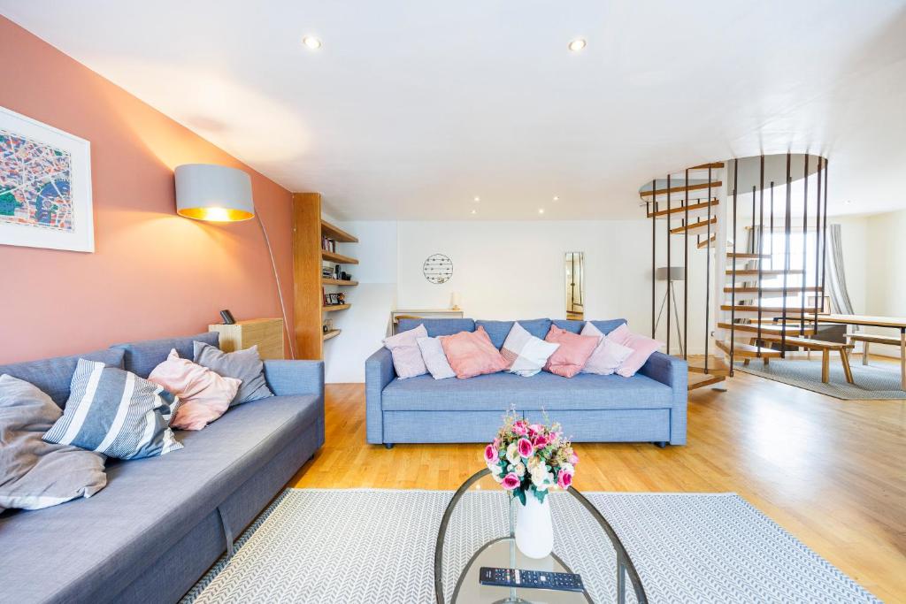 ein Wohnzimmer mit einem blauen Sofa und einer Treppe in der Unterkunft Hyde Park Adventures in London