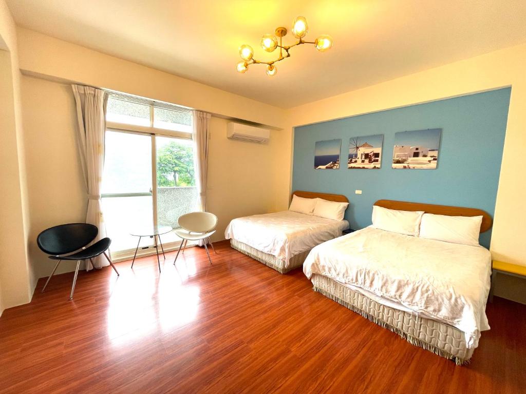 sypialnia z 2 łóżkami i żyrandolem w obiekcie Hong Ting Xuan w mieście Taidong