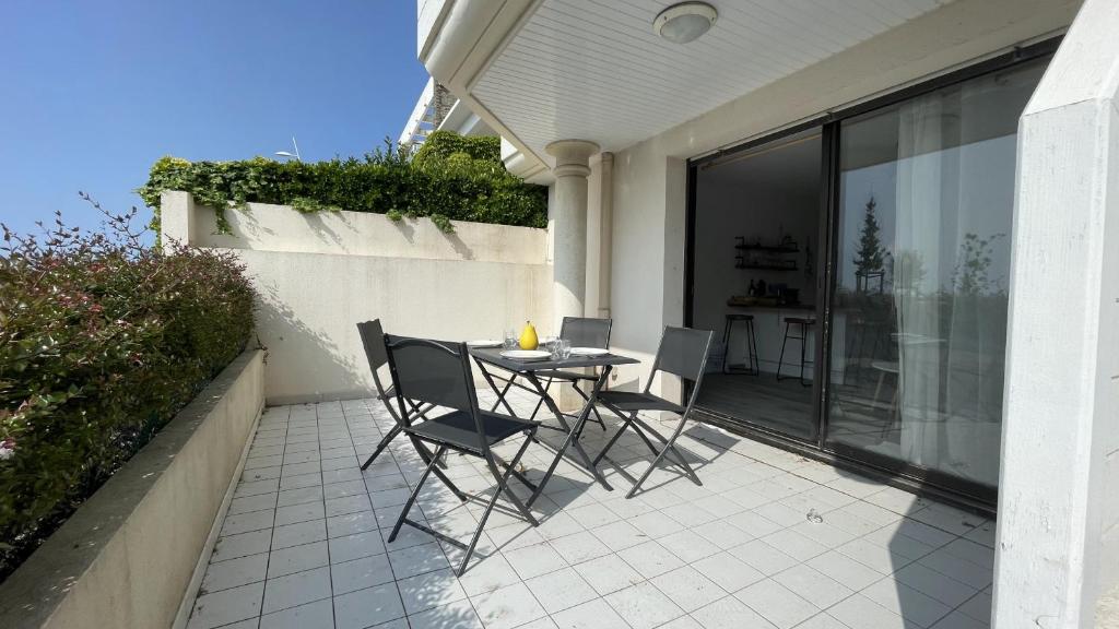 un patio avec une table et des chaises sur un balcon dans l'établissement Terrasse de la Tour du Port, à Saint-Gilles-Croix-de-Vie