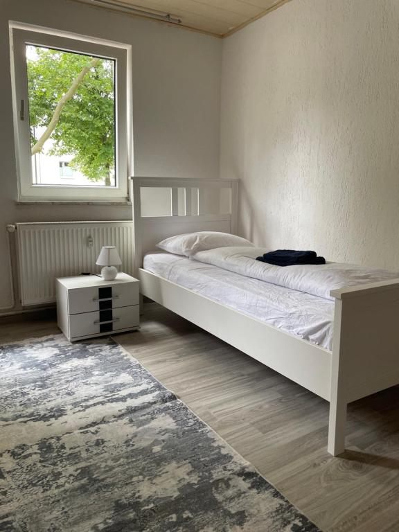 a white bedroom with a bed and a window at Ferienwohnung Monteurwohnungen Kassel Zentral lll in Kassel
