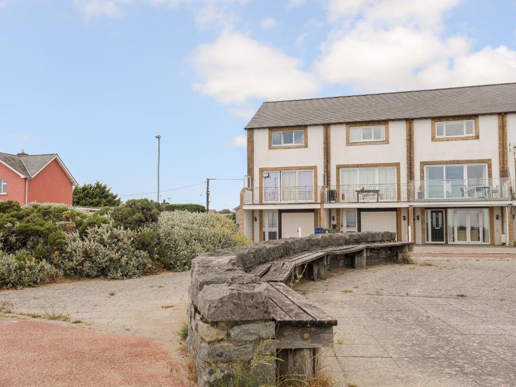 a large house with a stone bridge in front of it at 7 Min Y Traeth in Pwllheli