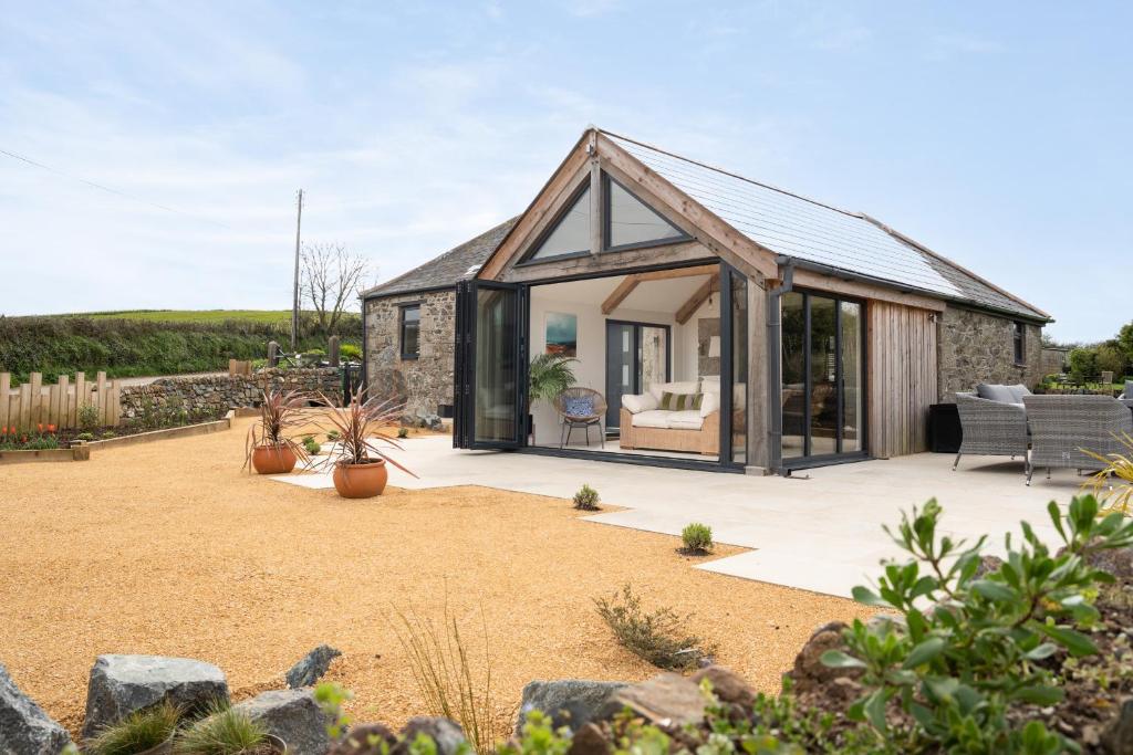 a house with a conservatory in a garden at The Rum House in Helston