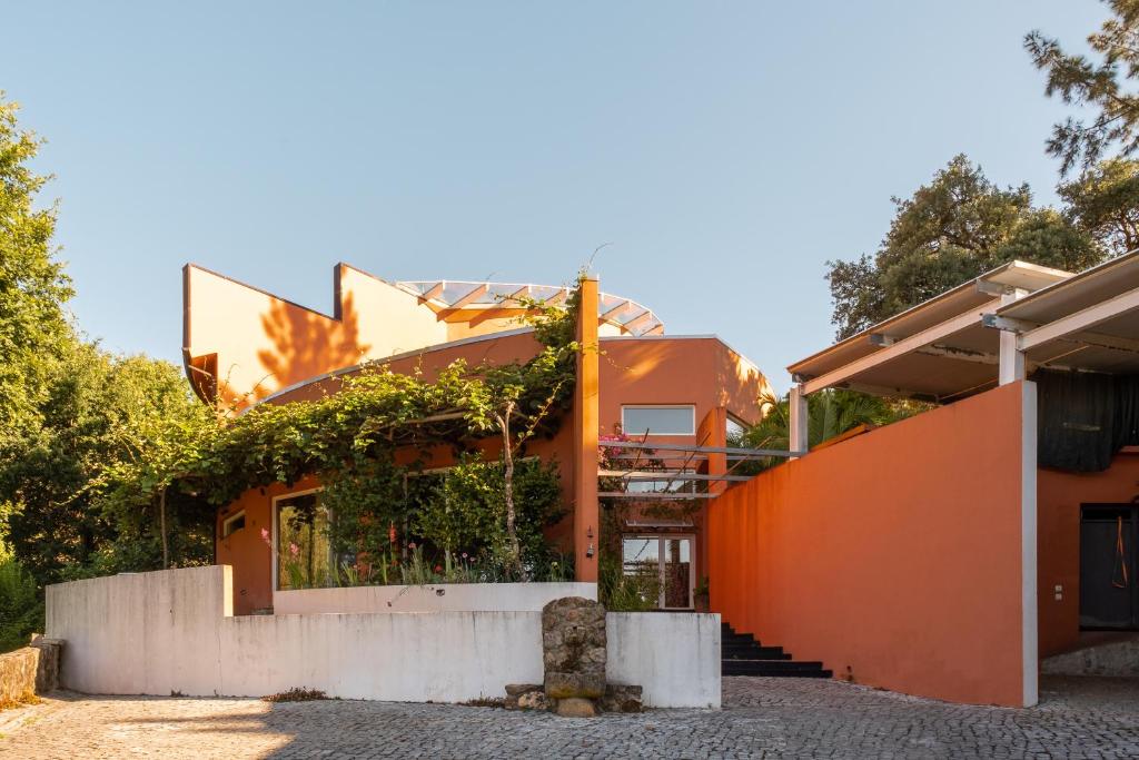 an orange house with an orange wall at Quinta dos Sarilhos in Pedrógão Grande