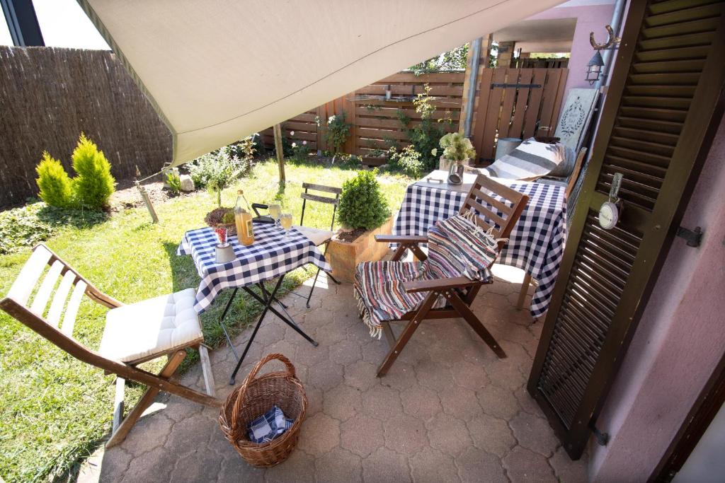 un patio avec une table et des chaises sur un patio dans l'établissement Maison d'hôtes du Mont, à Morschwiller