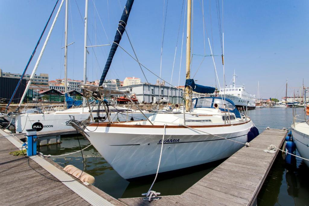 a white sail boat docked at a dock at Evamia Boat in Lisbon