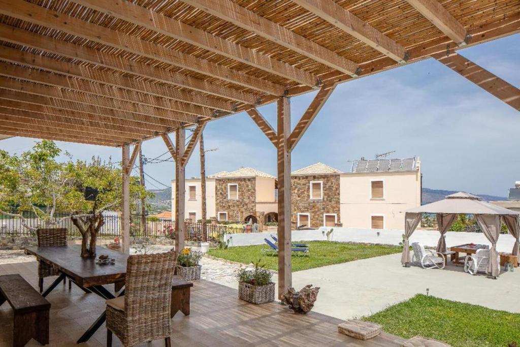 a patio with a table and chairs and a building at Pilot's Cottage Villa With Sea View in Tavronitis