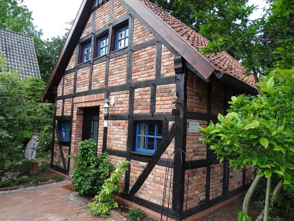 ein kleines Holzhaus mit einem blauen Fenster in der Unterkunft Ferienhaus Bultperle in Hüde