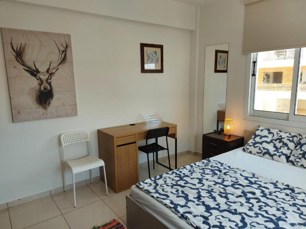 a bedroom with a bed and a desk with a deer on the wall at Pyla Palms A2 107 in Pyla