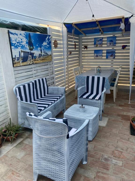a patio with wicker chairs and tables on a patio at Villa Valentina Versilia in Viareggio