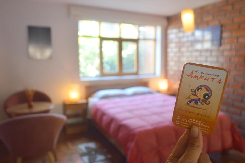 a person holding up a book in front of a bed at Amelita Hotel Boutique in Huaraz