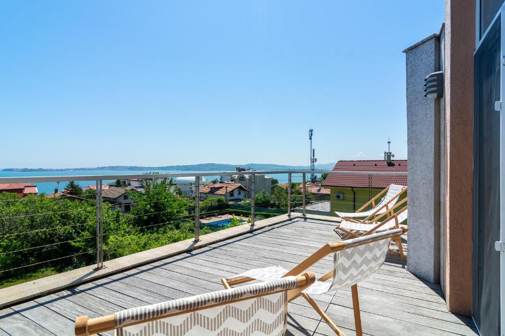 a balcony with two chairs and a view of the ocean at Happy-U house - Modern and with stunning view in Chernomorets
