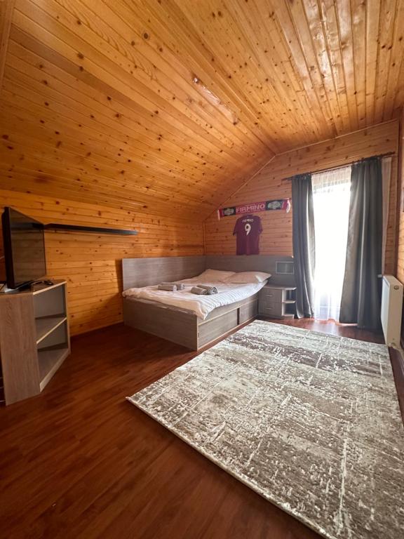 a bedroom with a bed and a rug in a room at Ollie's Mountain Chalet in Buşteni