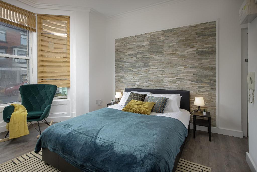une chambre avec un lit et un mur de briques dans l'établissement Seaside Suite 1 - Great Location Perfect For Long Stays, à Blackpool