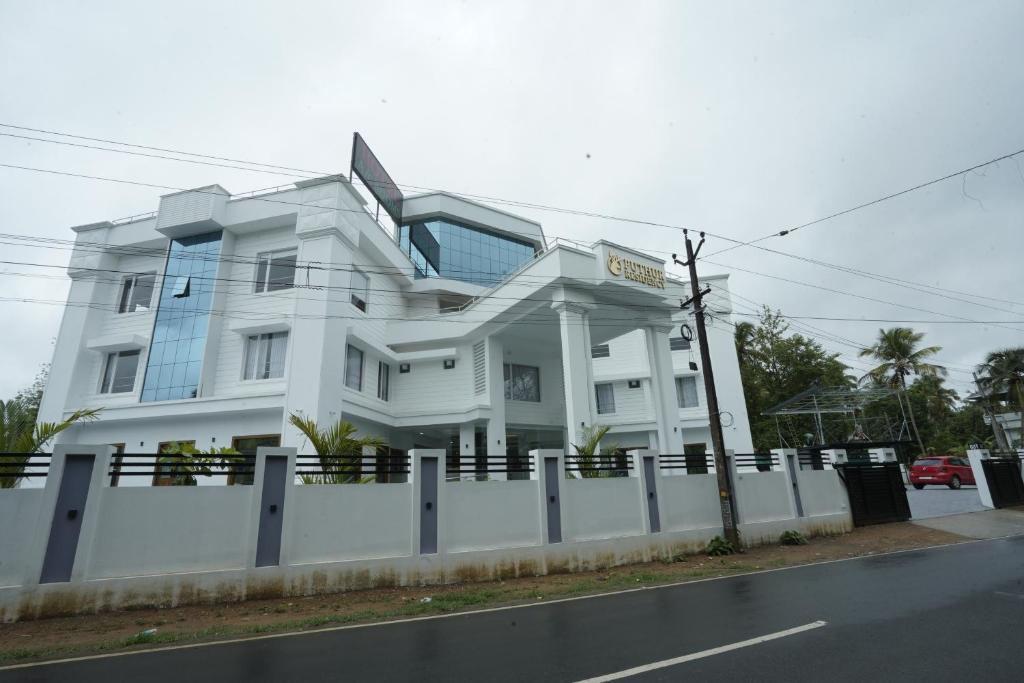a white building on the side of a street at PUTHUR RESIDENCY HOTELS PVT LTD in Trichūr