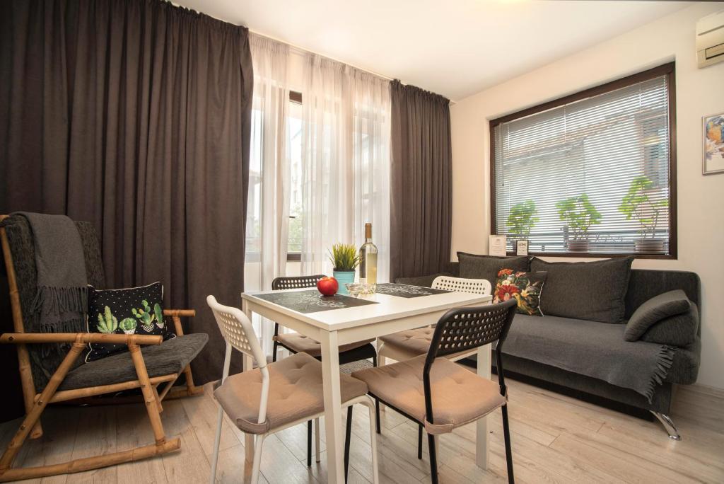 sala de estar con mesa, sillas y sofá en Apartament Vera en Varna