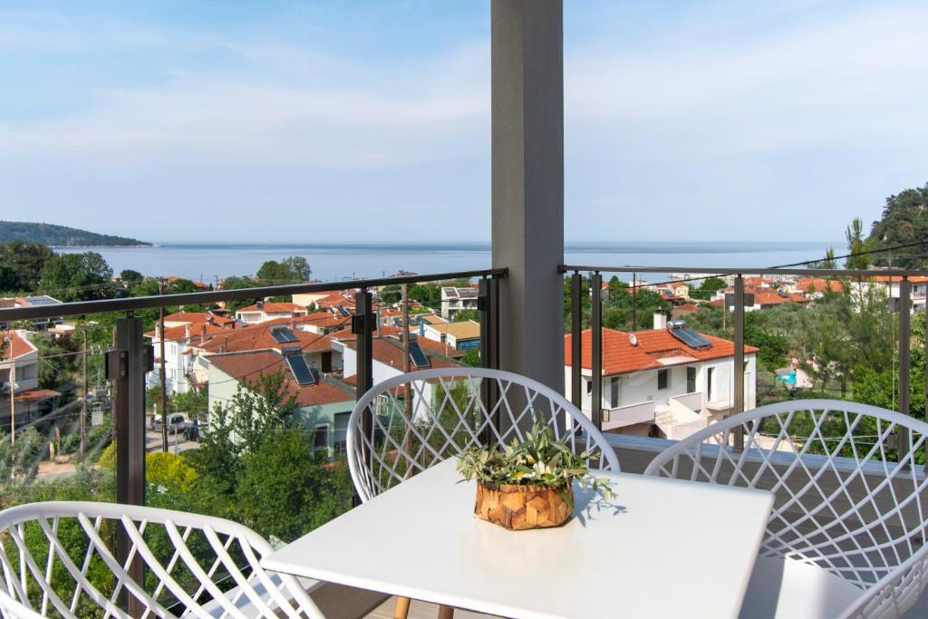 un tavolo bianco e sedie su un balcone con vista di Green Hill Thassos a Skala Potamias