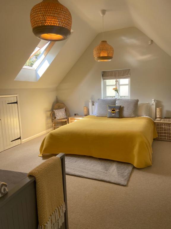 a bedroom with a large yellow bed in a attic at The Nookery in Winscombe