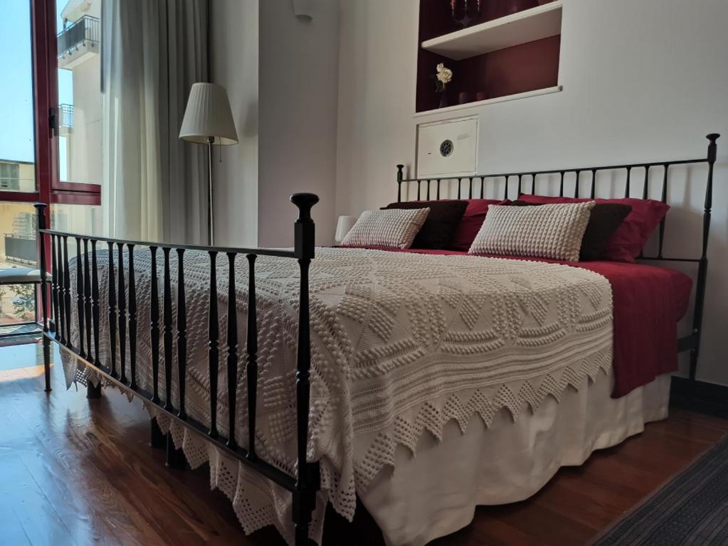 a bedroom with a large bed with red pillows at CASA ODELLO suite and the sea in Bordighera