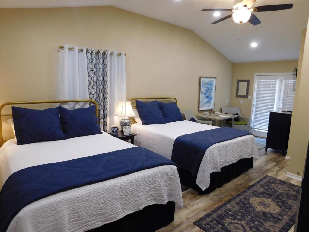 a bedroom with two beds and a ceiling fan at Rainbow Courts in Rockdale