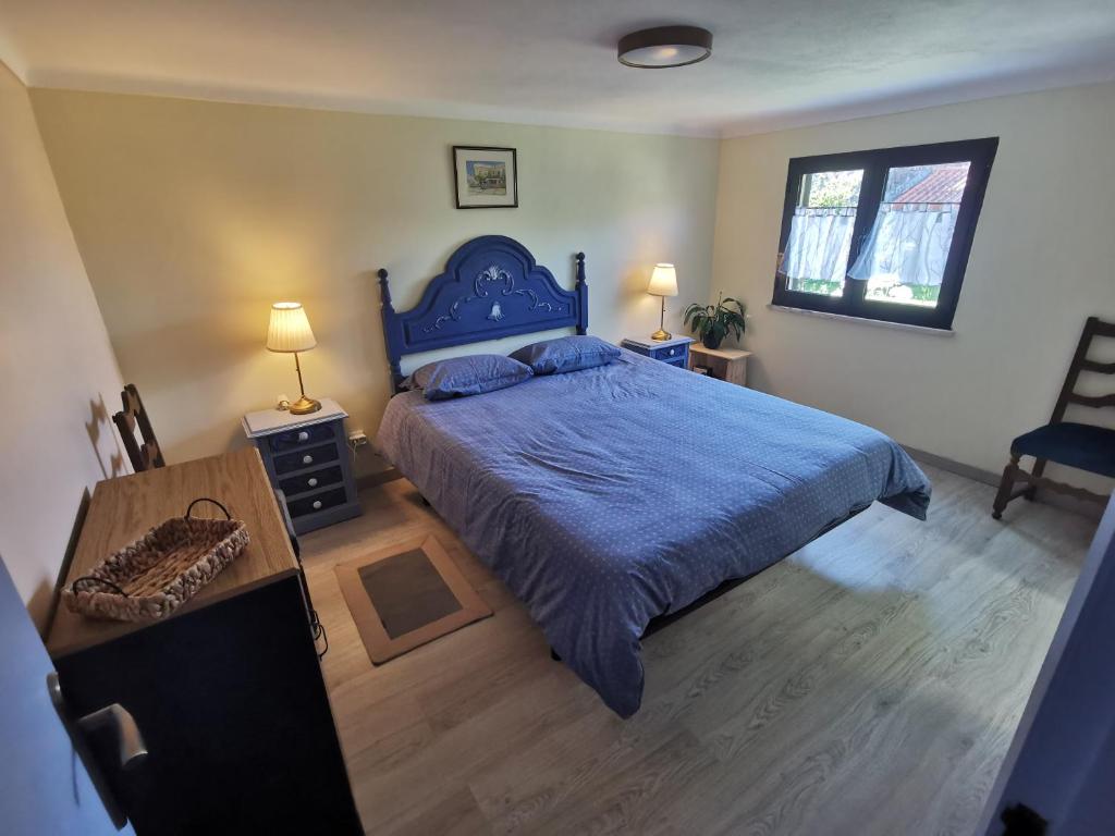 1 dormitorio con 1 cama azul y suelo de madera en Casa São Pedro Belinho ONLY PILGRIMS, en Belinho