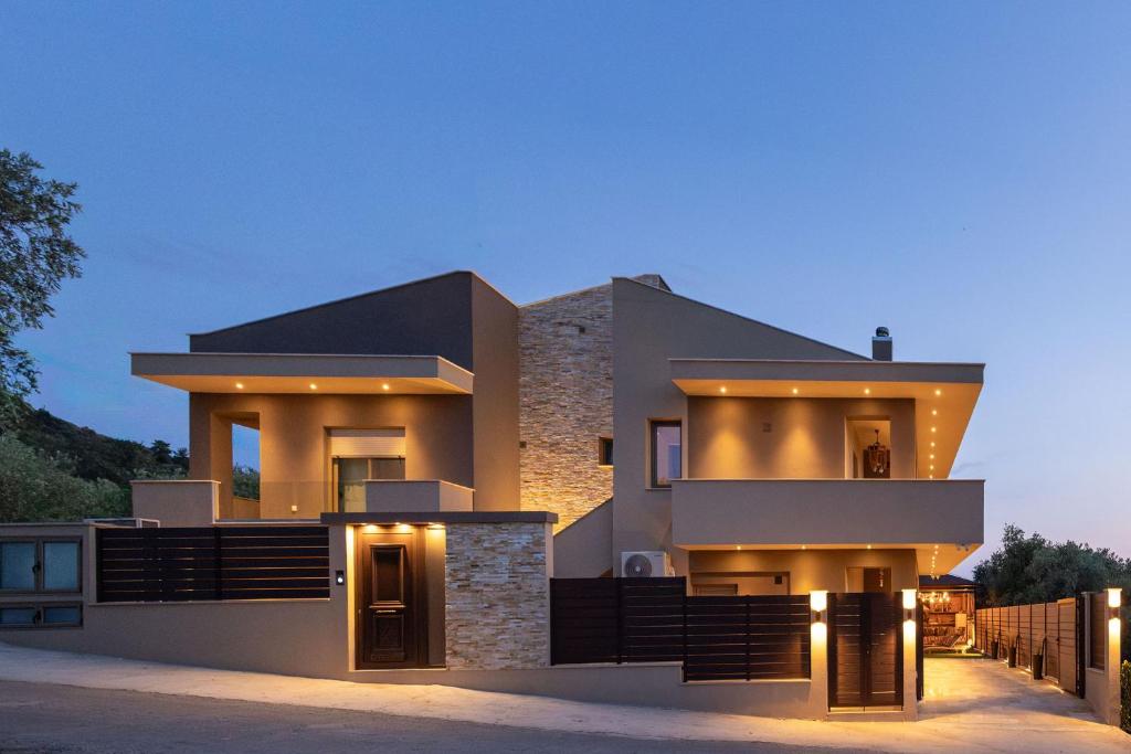 a modern house with lights on it at night at Villa Nous luxury in Skala Sotiros