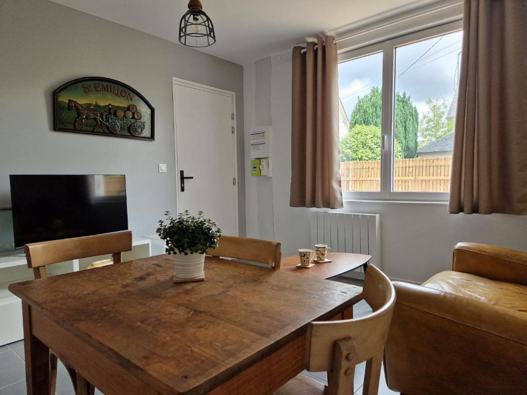 uma sala de estar com uma mesa de madeira e um sofá em Le 4.01 proche centre em Lannion