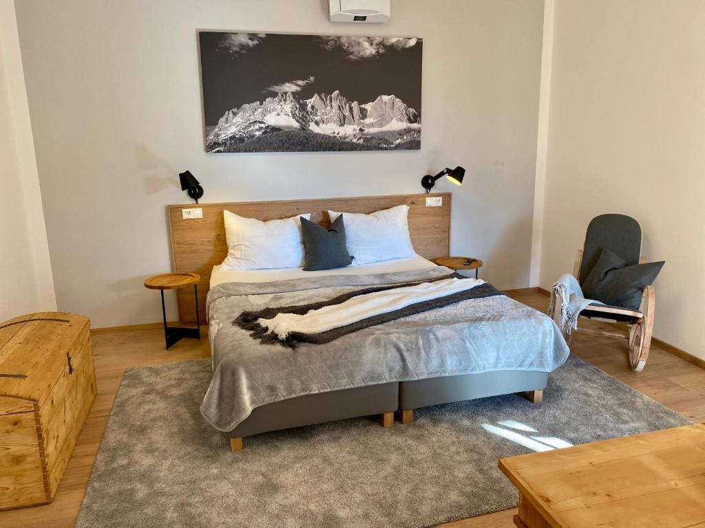 een slaapkamer met een bed en een stoel bij s'pölven NEST in Bad Häring