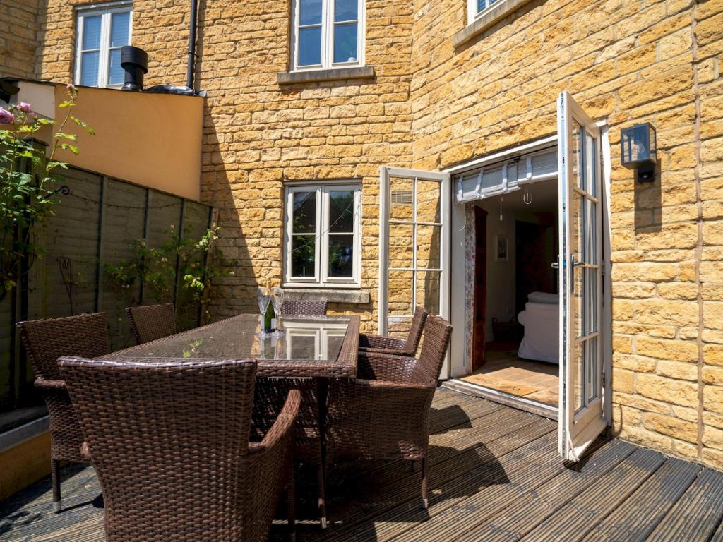 a patio with a table and chairs on a wooden deck at Pass the Keys Lovely 4 bedroom family home with garden parking in Cheltenham